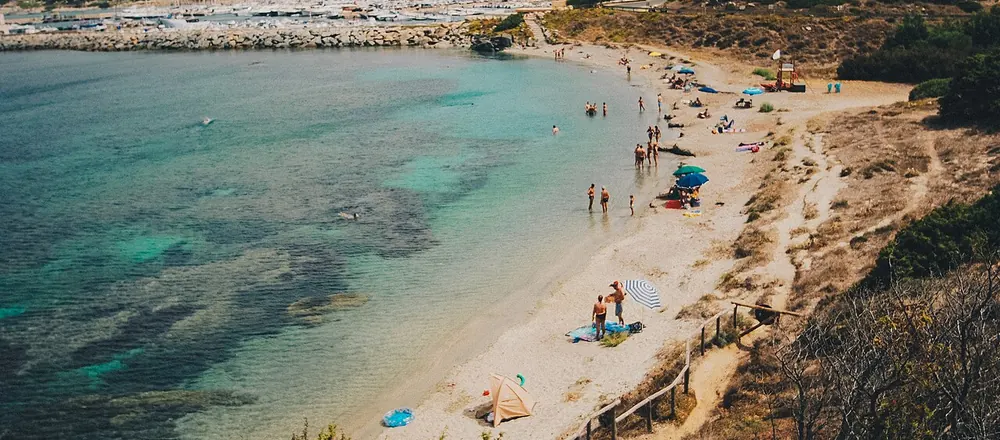 Crique de sable avec une eau turquoise et des baigneurs